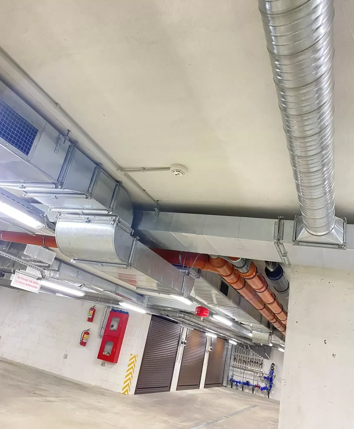 Sistem de ventilare și evacuare a fumului instalat într-o parcare subterană